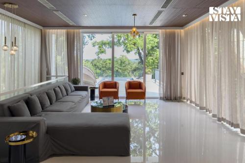 a living room with a couch and two chairs at StayVista at Casa Canto with Infinity Pool in Siolim