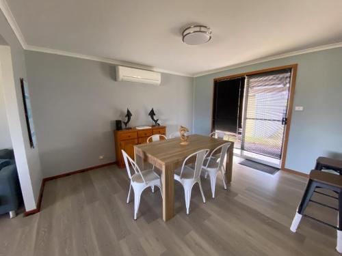 a dining room with a wooden table and chairs at Sea Breeze in Lancelin