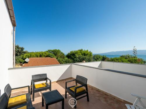 La Casa sul Mare في San Vero Milis: اطلالة من الشرفة على منزل به كراسي وطاولات