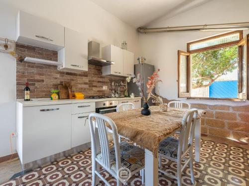 La Casa sul Mare في San Vero Milis: مطبخ مع طاولة وكراسي في الغرفة