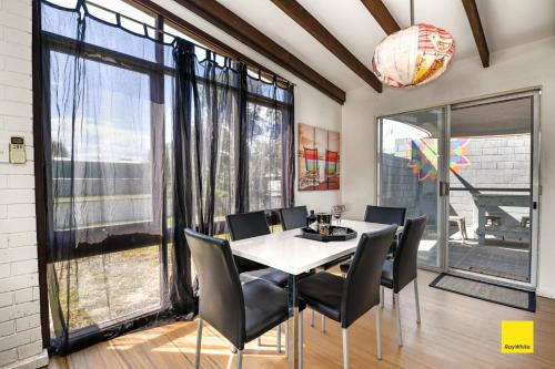 a dining room with a table and chairs and a large window at Sea Gem in Lancelin