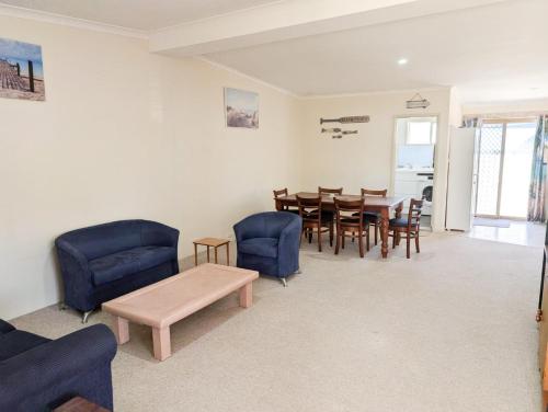 a living room with a dining room table and chairs at Aqua Sands Chalets in Lancelin