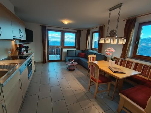 a kitchen and living room with a table and a couch at Oberplatzer in Foresta