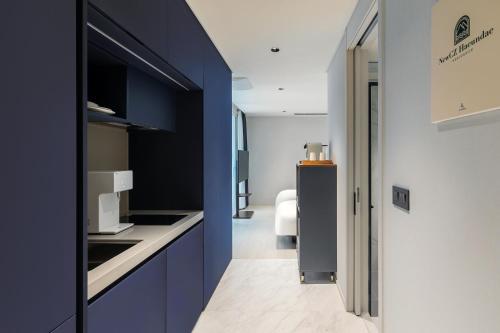 a kitchen with blue cabinets and a refrigerator at NewCZ Haeundae Residence in Busan