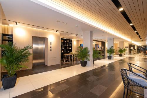 a lobby with potted plants in a building at Leenova Hotel in Bangkok