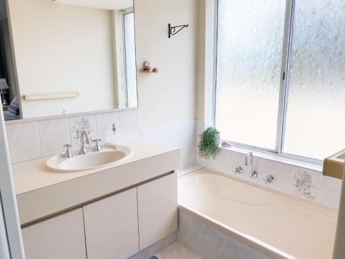 a bathroom with a sink and a tub and a window at Sea-renity Now in Lancelin