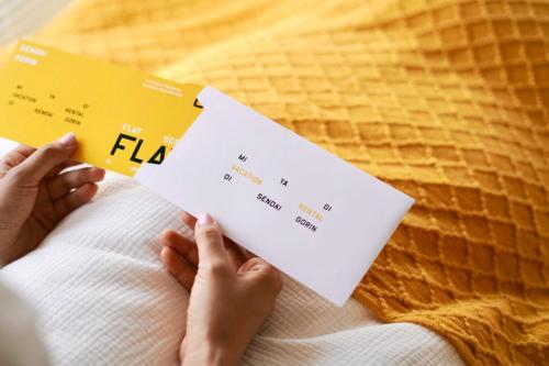 a person sitting on a bed holding a flu card at Sendai FLAT 01 GORIN in Sendai