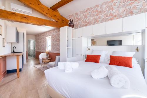 a bedroom with a large white bed with red pillows at La Réserve de Salon de Provence in Salon-de-Provence
