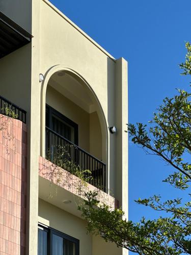 a building with a balcony and a blue sky at Cốc Cốc Homestay Quảng Bình in Dong Hoi
