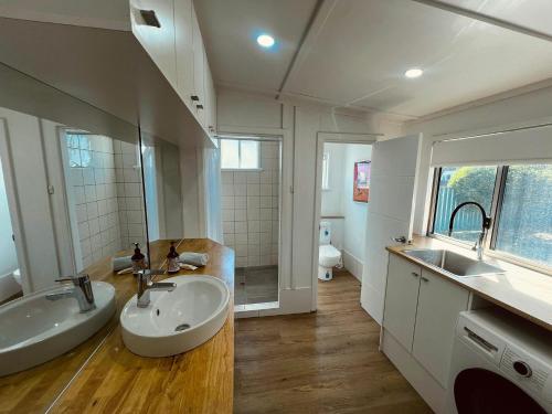 a bathroom with two sinks and a mirror at Playgrounds in Lancelin