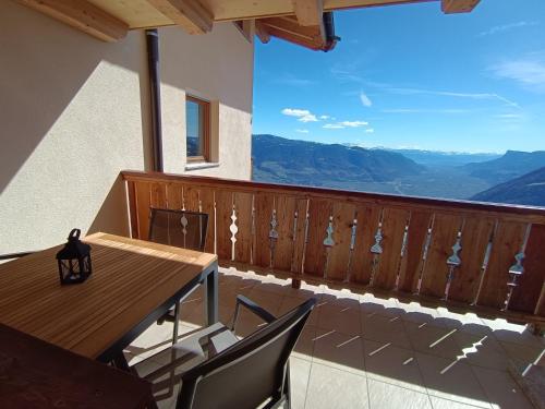 a balcony with a wooden table and chairs and a view at Oberplatzer in Foresta