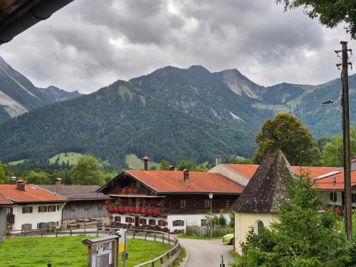 a village with buildings and mountains in the background at Wildstein - Rote Wand in Bayrischzell