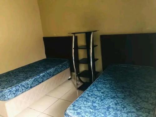 a room with two beds and a shelf at The Hope Apartments in Nelspruit