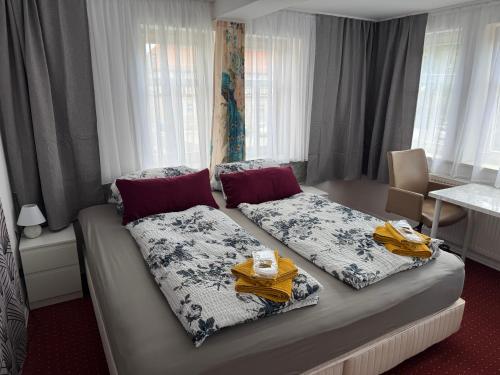 a hotel room with a bed with two blankets and a table at Ferienwohnung Vierjahreszeiten Sommer in Bad Langensalza