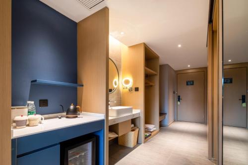 Un baño con chimenea y pared azul en Mercure Nanjing Sun Yat-sen Mausoleum, en Nanjing