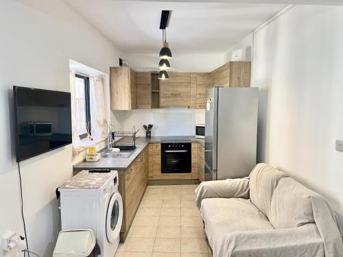 a small kitchen with a couch and a refrigerator at Be Happy Three-Bedroom Apartment in St. Paul's Bay