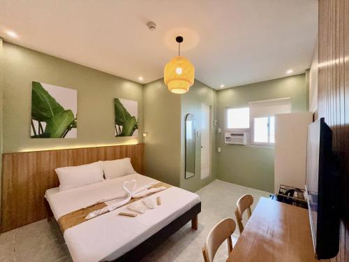 a bedroom with a bed and a table and a tv at ABC Homes PH in Olongapo