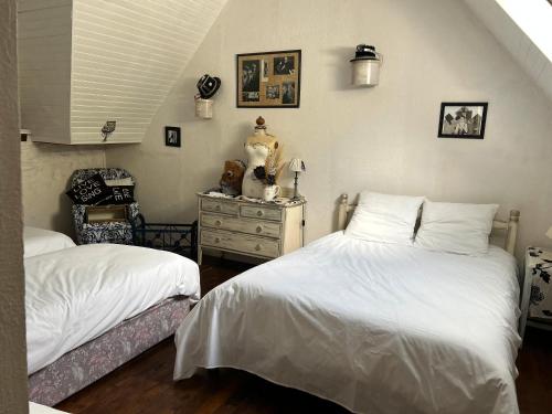 a bedroom with two twin beds and a dresser at Domaine les Hiboux in Neulliac