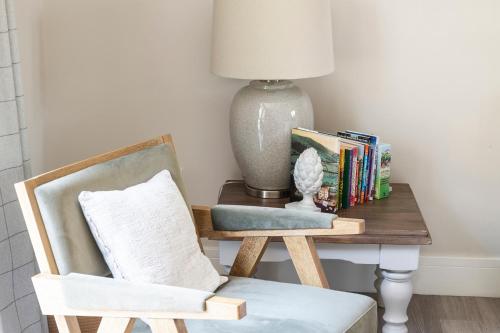 a table with a chair and a lamp and books at Rowan Cottage-Ebrington in Ebrington