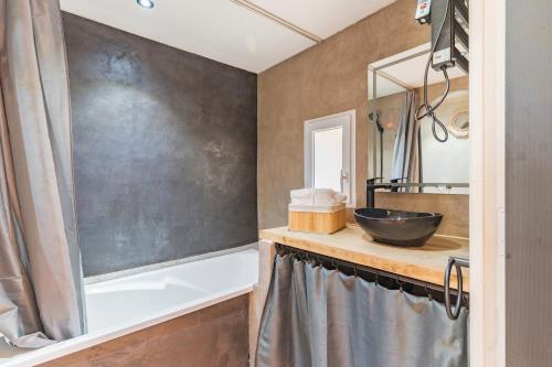 a bathroom with a sink and a bath tub at Domaine Plan Des Devens Volupté in Roussillon