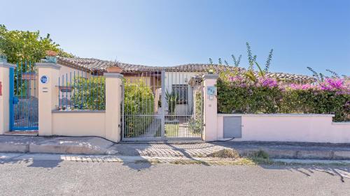 una puerta a una casa con flores rosas en Casa Gio, en Tortolì