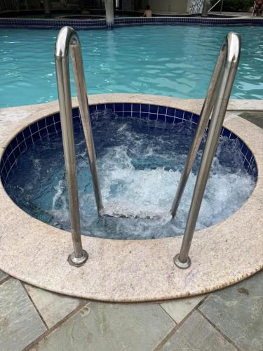 a swimming pool with two metal poles in it at Roma DiFiori in Caldas Novas