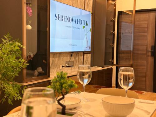 a table with two wine glasses and a screen at 豪华市中心联排别墅-暹罗百丽宫-siam in Pratunam
