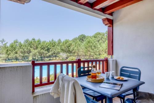 a table and chairs on a balcony with a view at Résidence Pierre & Vacances Le Domaine de Gascogne in Biscarrosse