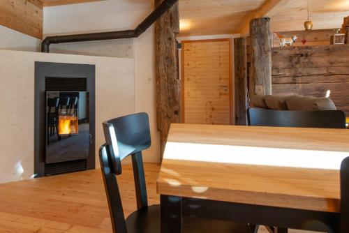 a dining room with a table and a fireplace at Chalet Himmel - Top renoviertes Walliserhaus in Biel VS in Ritzingen