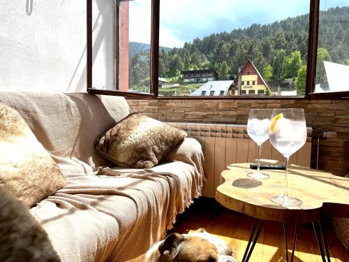 een woonkamer met een bank en een tafel met wijnglazen bij Dúplex la Molina in La Molina