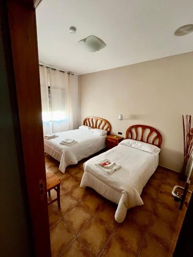 a room with two beds in a room at Hostal Castilla in Mocejón