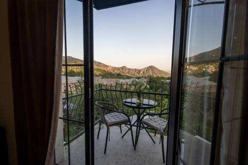 a balcony with a table and chairs and a view at REDROOF country house hotel in Goris