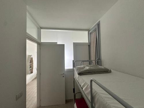 a small bedroom with a bed and a hallway at Feli's Apartment in Castelsardo