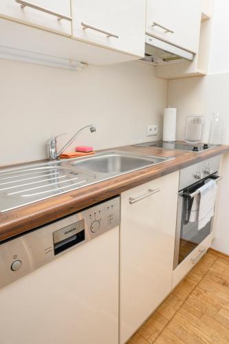 a kitchen with white cabinets and a sink at Quiet & Comfortable Studio Apartment in Vienna in Vienna