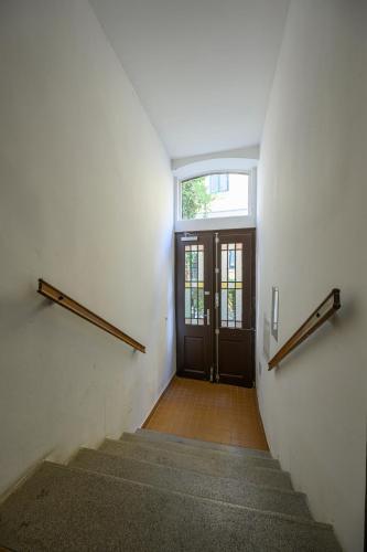 a hallway with a door and stairs with a window at Quiet & Comfortable Studio Apartment in Vienna in Vienna