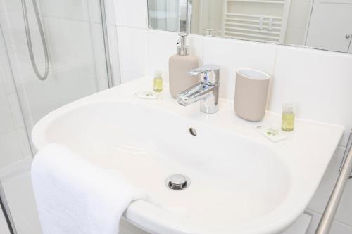 a white bathroom with a sink and a shower at Quiet & Comfortable Studio Apartment in Vienna in Vienna