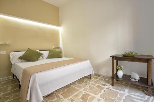 a bedroom with a bed and a side table at Donna Lucia by Armerina Sicily Apartments in Piazza Armerina
