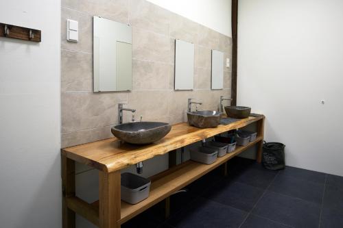 a bathroom with two sinks on a wooden counter with mirrors at Bed & Breakfast Twekkelo in Enschede