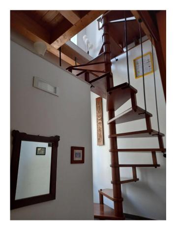 a wooden spiral staircase in a white room at Gradem in Bitonto