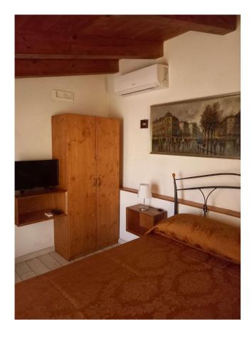 a bedroom with a bed and a dresser with a television at Gradem in Bitonto