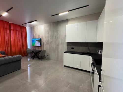 敖德萨ЖК Атмосфера первая линия моря место паркинг的配有沙发和桌子的厨房和客厅