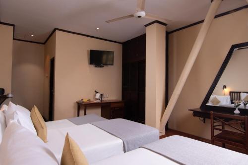 a hotel room with two beds and a television at Oak Ray Colombo City Hotel in Colombo