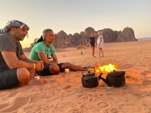 two men sitting around a campfire in the desert at Wadi Rum Magic Camp in Wadi Rum