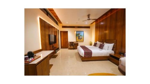 a hotel room with a bed and a television at Araiya Gir,A Mavintara Resort in Chitrāwal