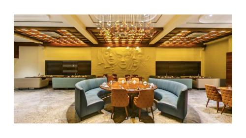 a dining room with a table and chairs and a chandelier at Araiya Gir,A Mavintara Resort in Chitrāwal