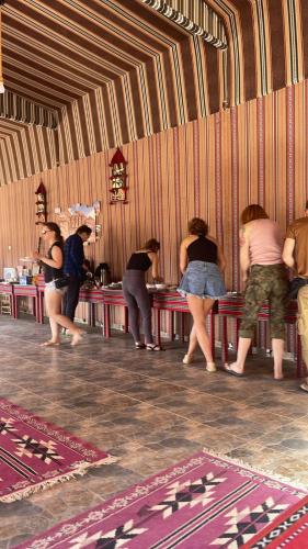 a group of people standing at a table at Wadi Rum Magic Camp in Wadi Rum