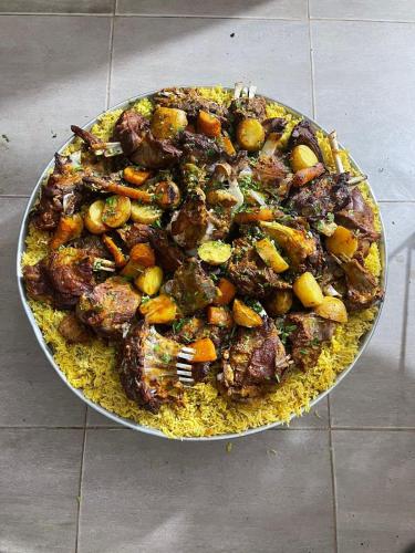 a pan of food with meat and vegetables on a table at Wadi Rum Magic Camp in Wadi Rum