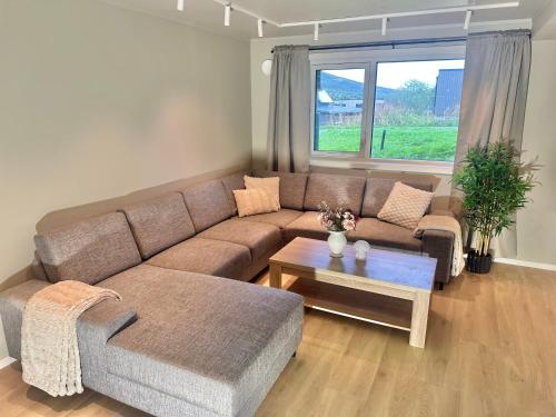 a living room with a couch and a table at Kaldfjord Aurora Aparments New in Tromsø