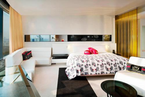 a hotel room with a bed and a chair at W Bangkok Hotel in Bangkok