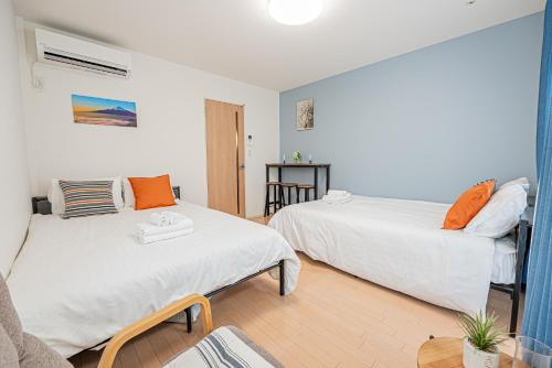 a bedroom with two beds and a couch at 301 6 mins walk from Higashi-Jujo Station Comfortable 1 bedroom apartment on the 3rd floor Direct access to Akihabara and Ueno in Tokyo